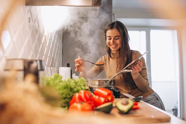 Mulher sorrindo ao cozinhar molho em panela